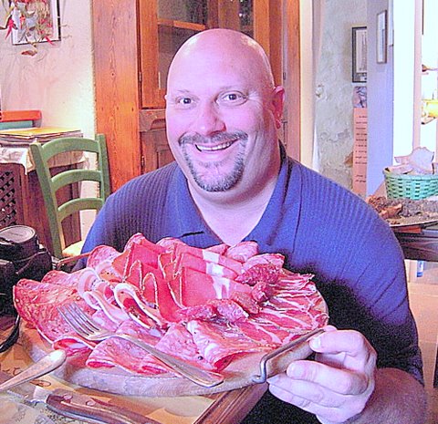 Lachende man met enorme plank varkensvlees